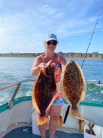 a person holding a fish on a boat in a body of water