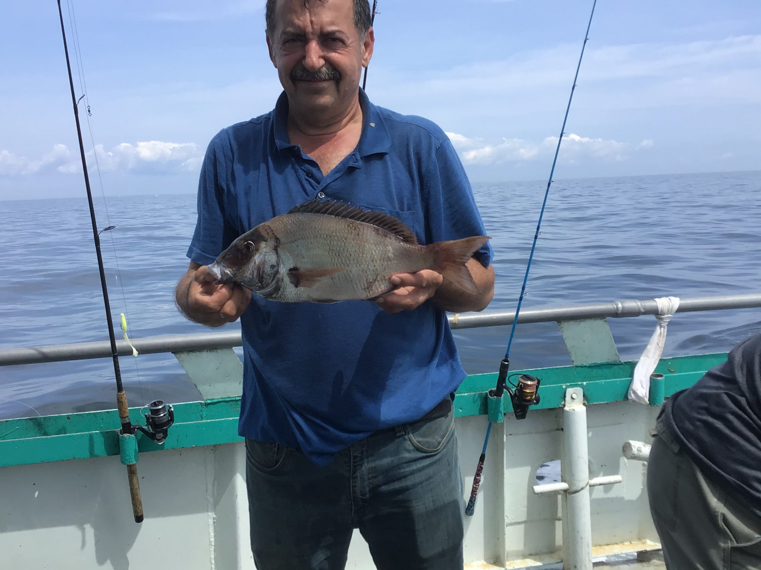 a man holding a fish on a boat