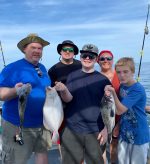a group of people standing next to a person holding a fish