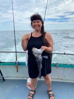 a woman standing in front of a body of water