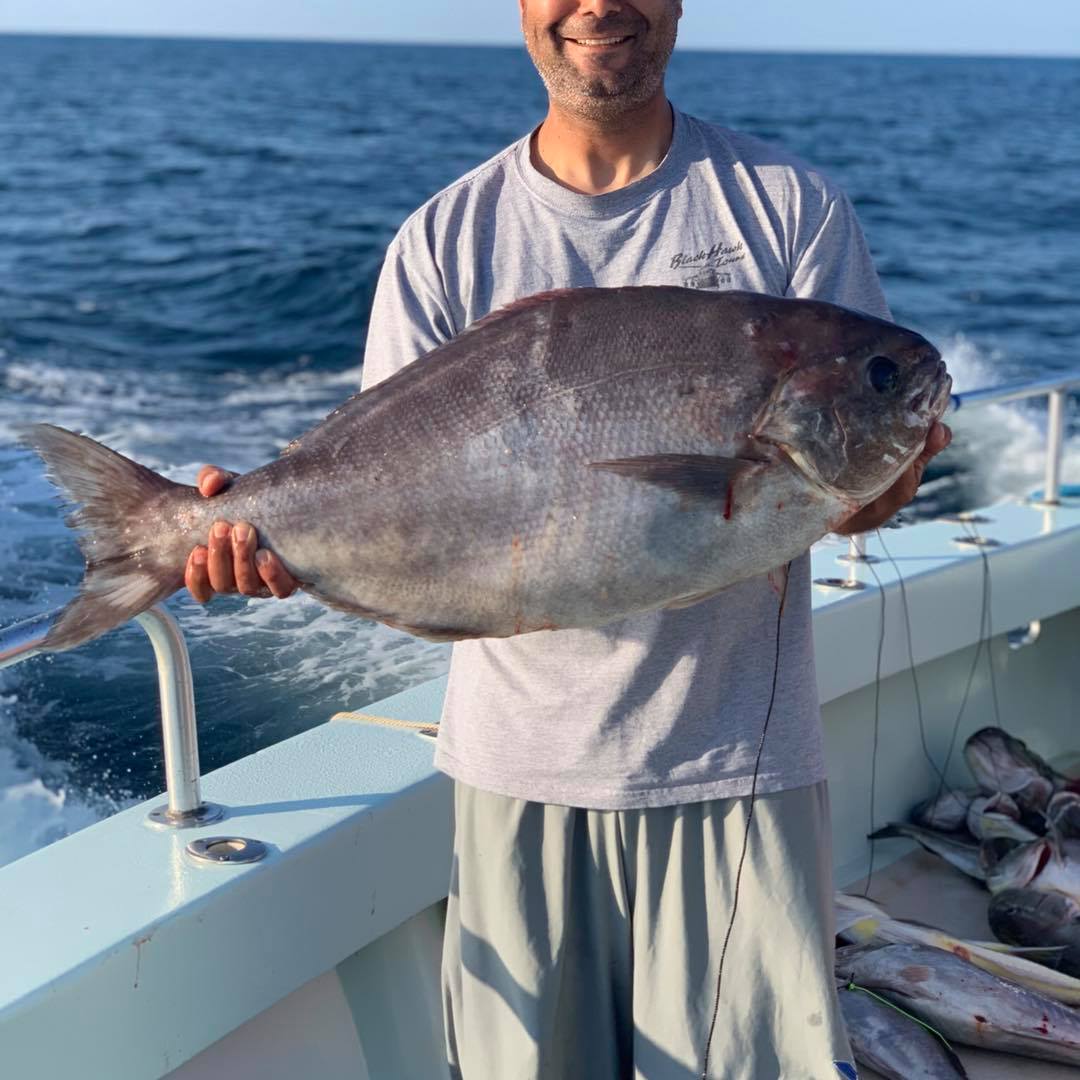 a man holding a fish in the water