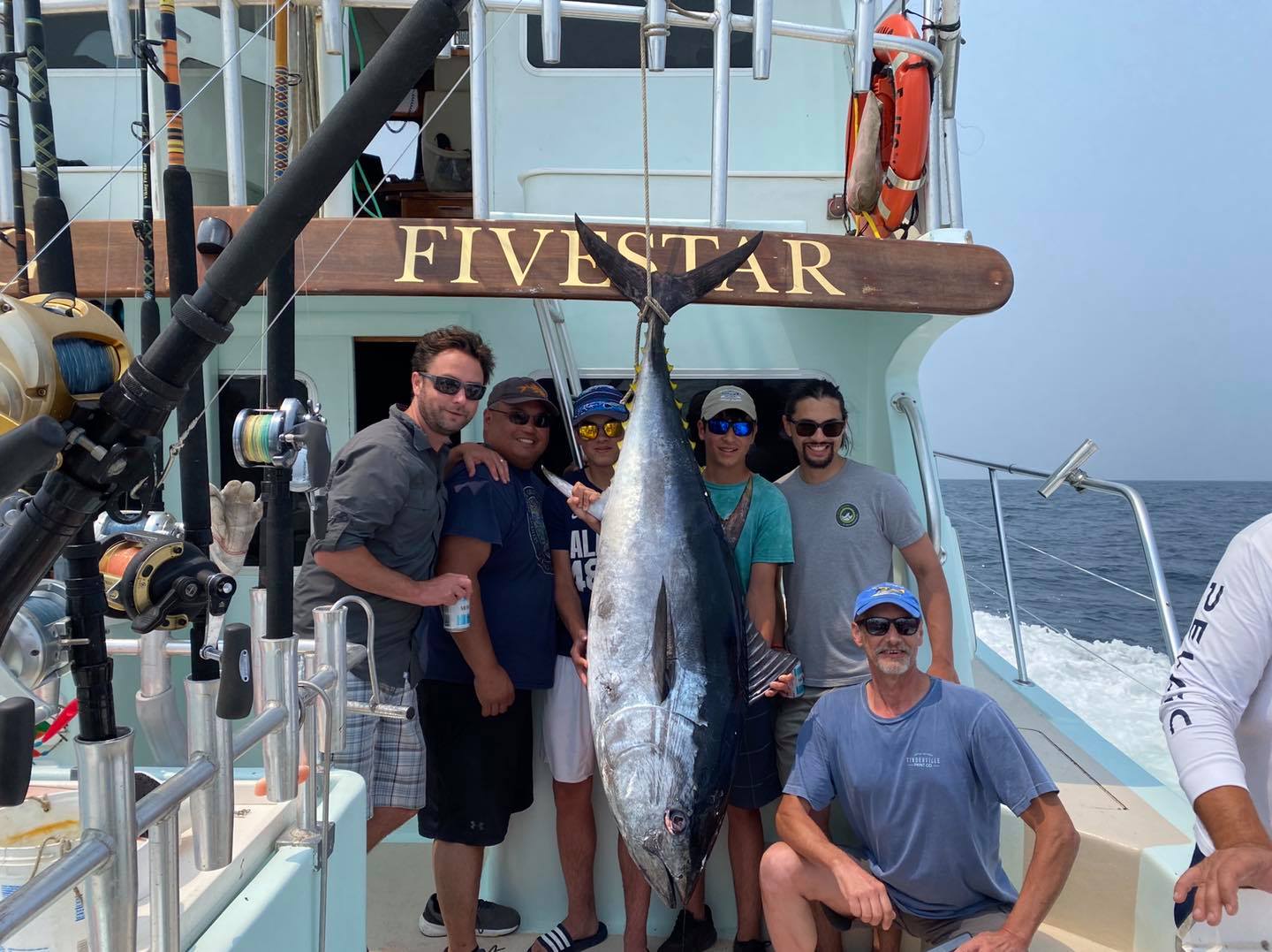 a group of people standing in front of a fish