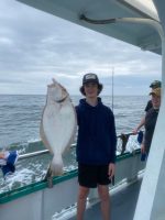a group of people standing next to a fish in the water