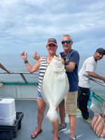 a group of people standing next to a fish in the water