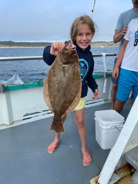 a person holding a fish on a boat in the water