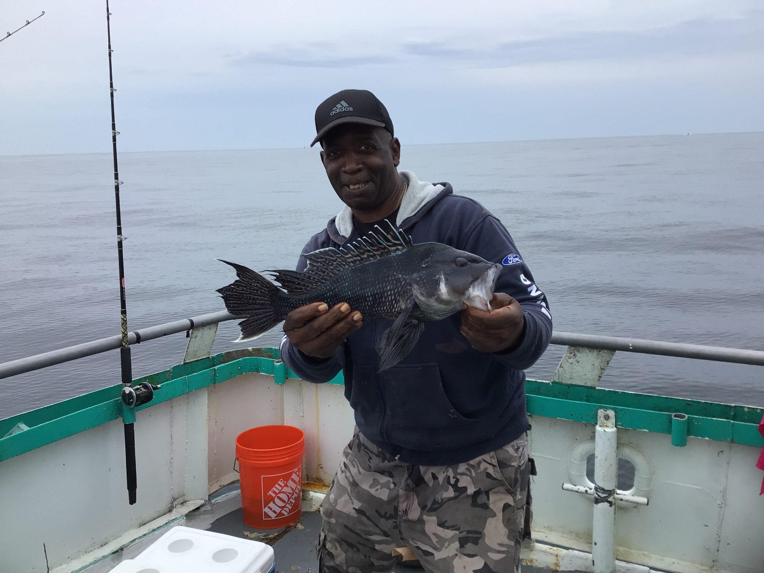 a man holding a fish on a boat in the water