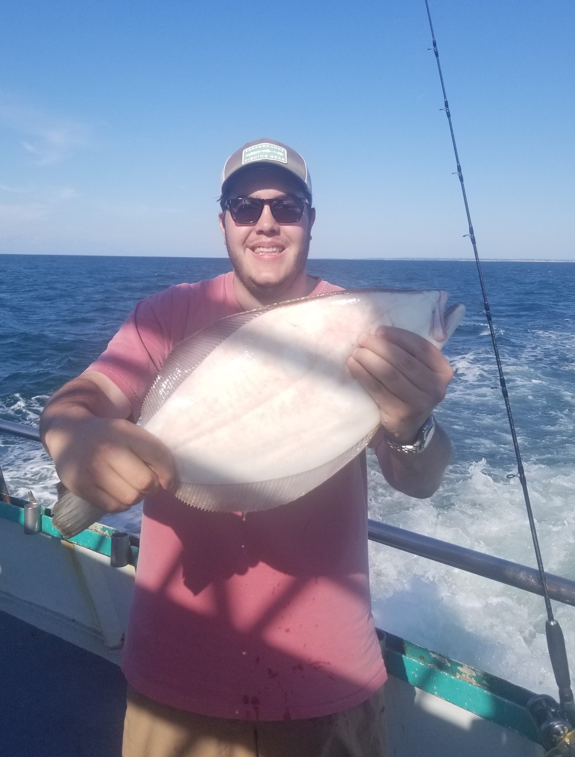 a person holding a fish on a boat in a body of water