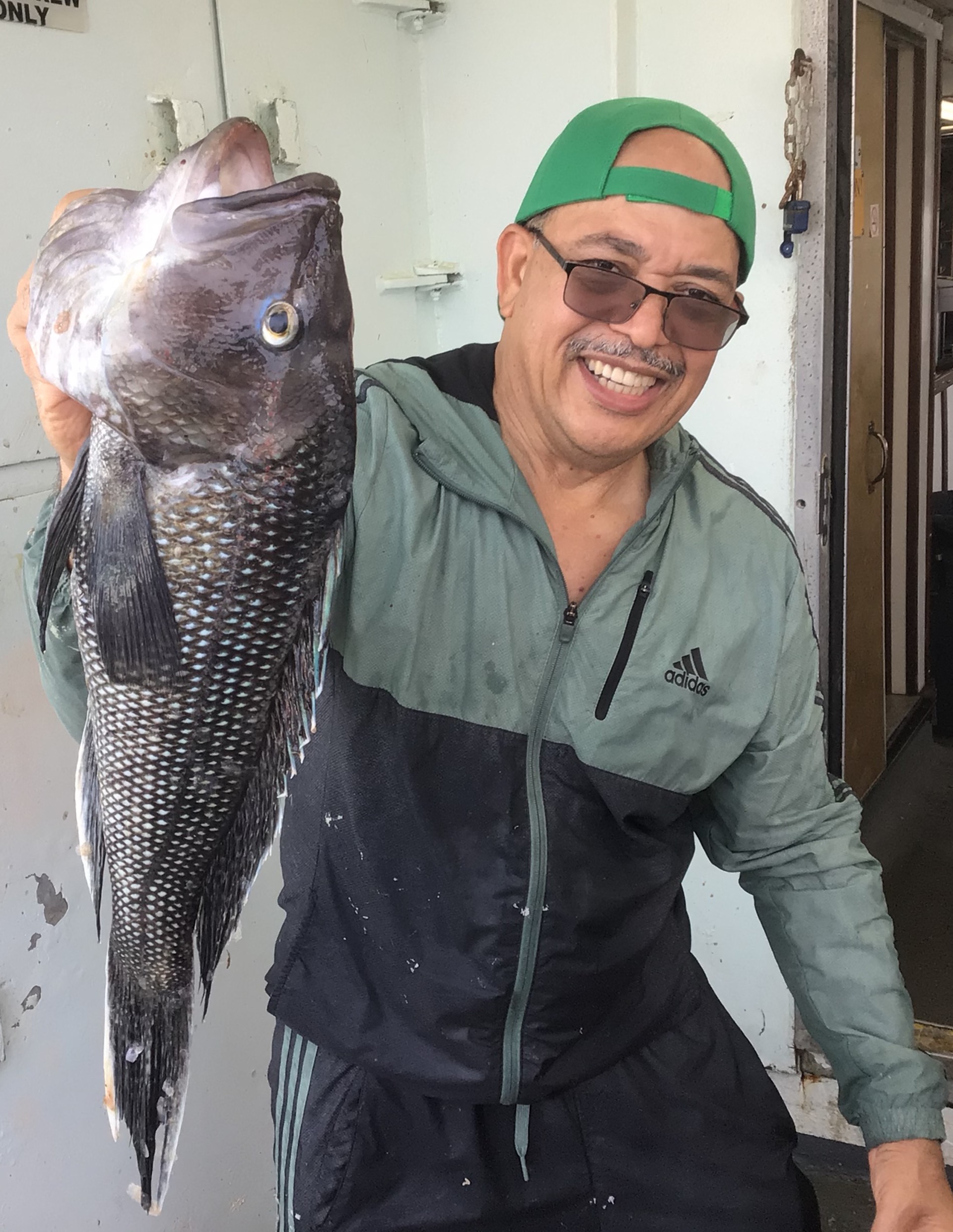 a person holding a fish posing for the camera