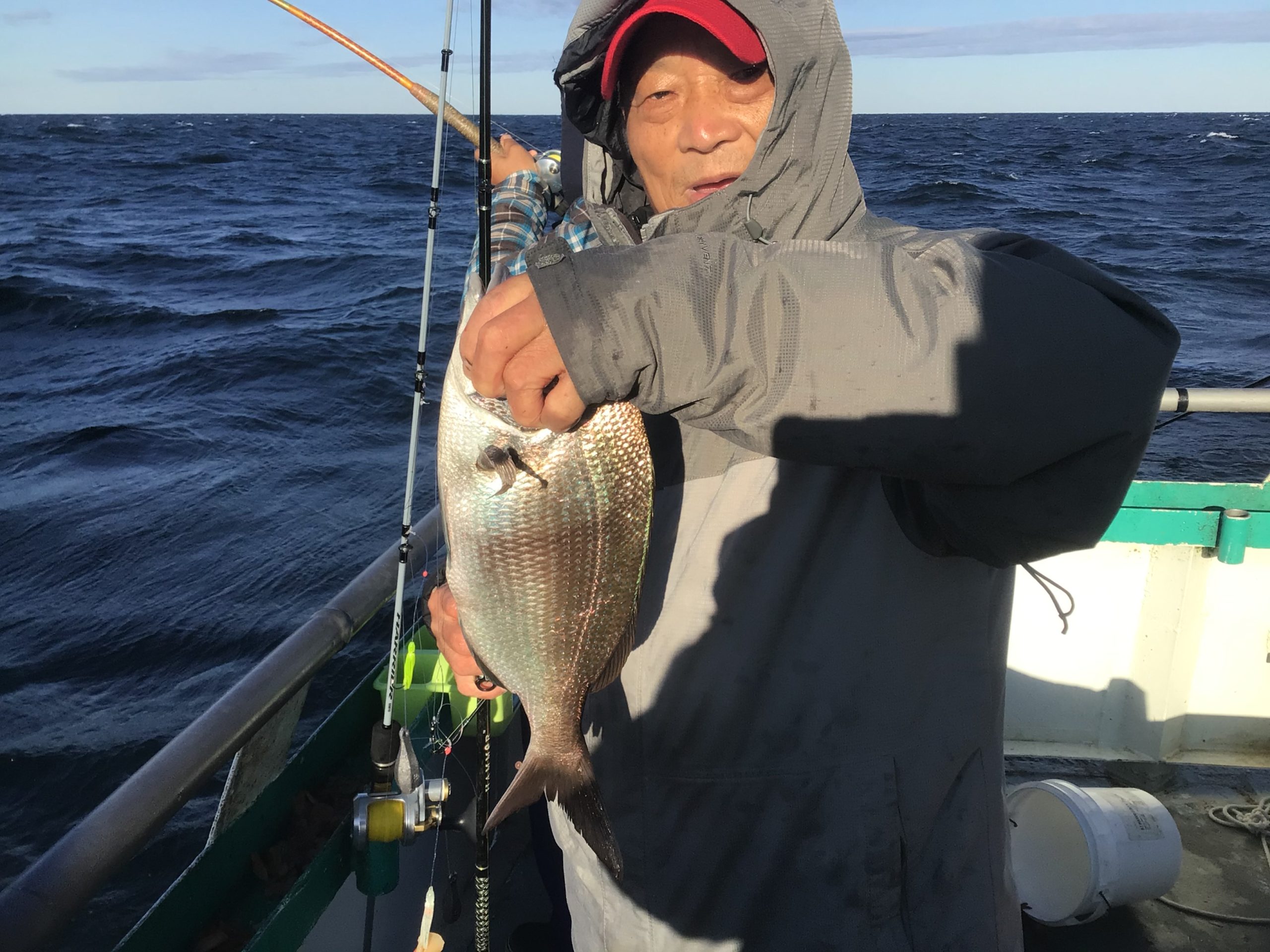a person holding a fish on a boat in a body of water