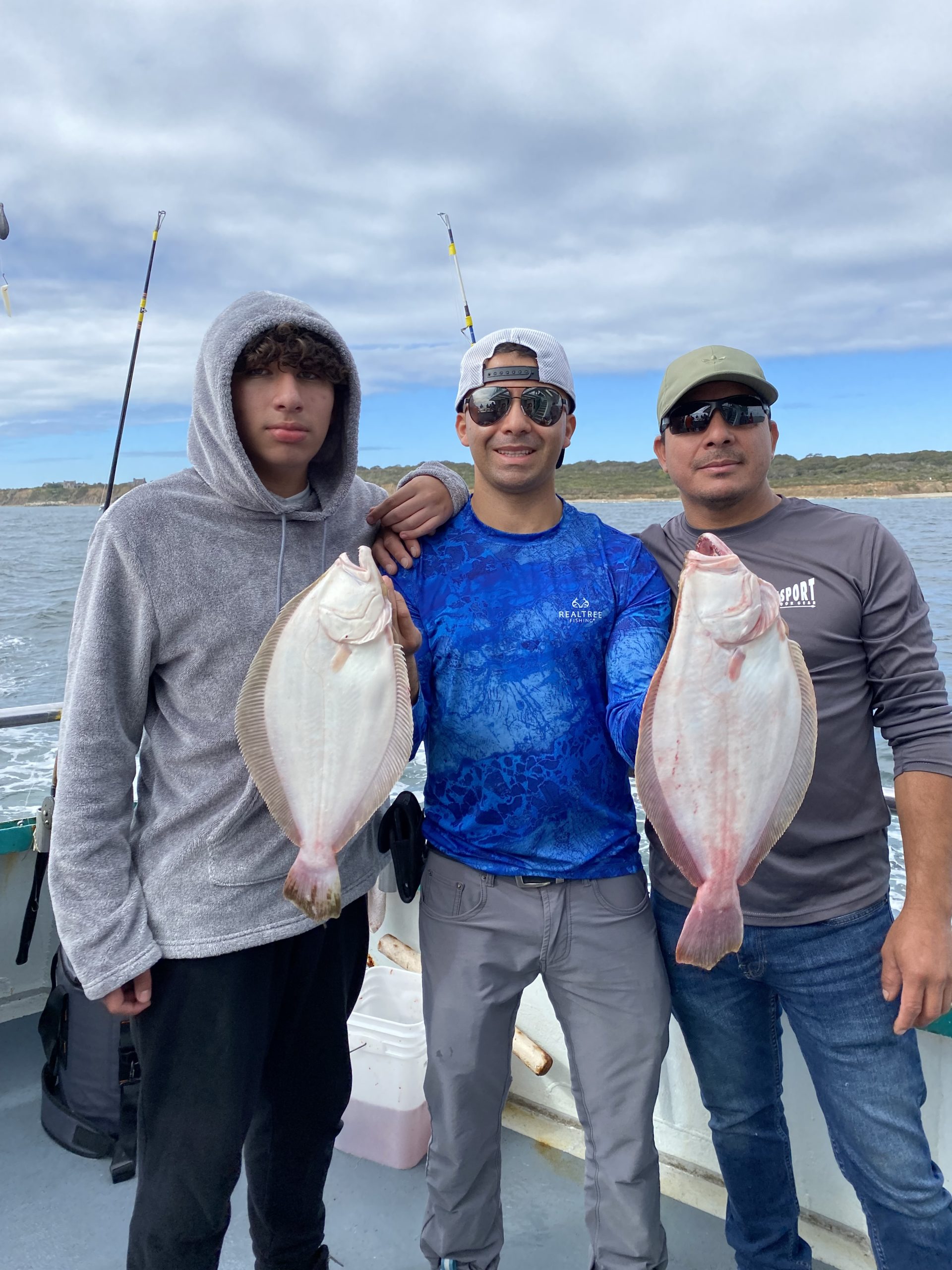 a group of people standing next to a person holding a fish