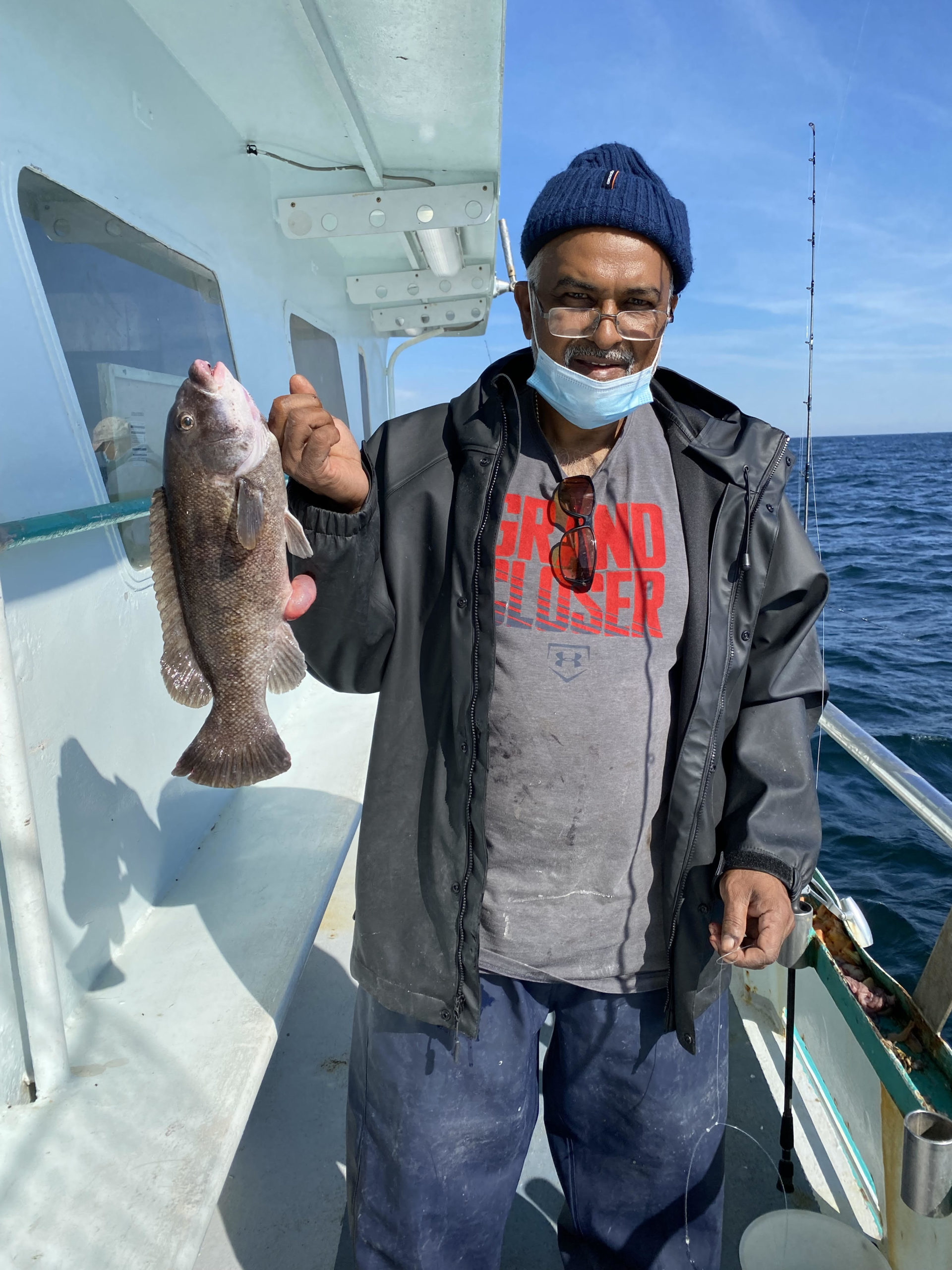 a man holding a fish on a boat