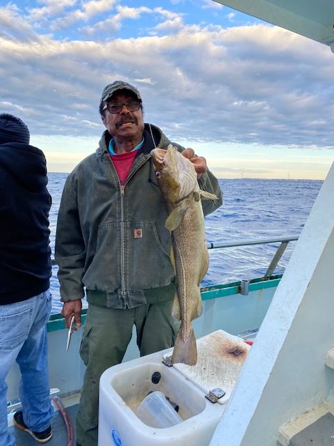 a person holding a fish on a boat in the water