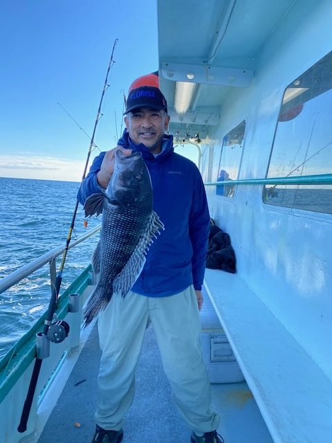 a man holding a fish on a boat