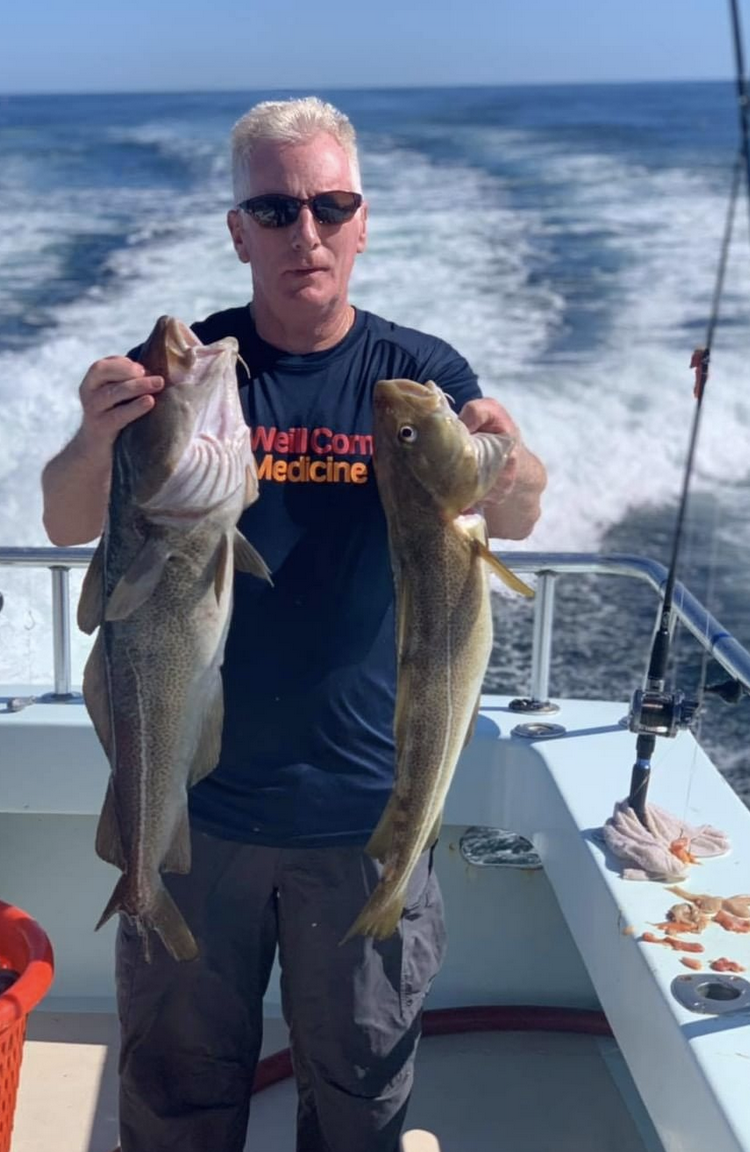 a man holding a fish in the water
