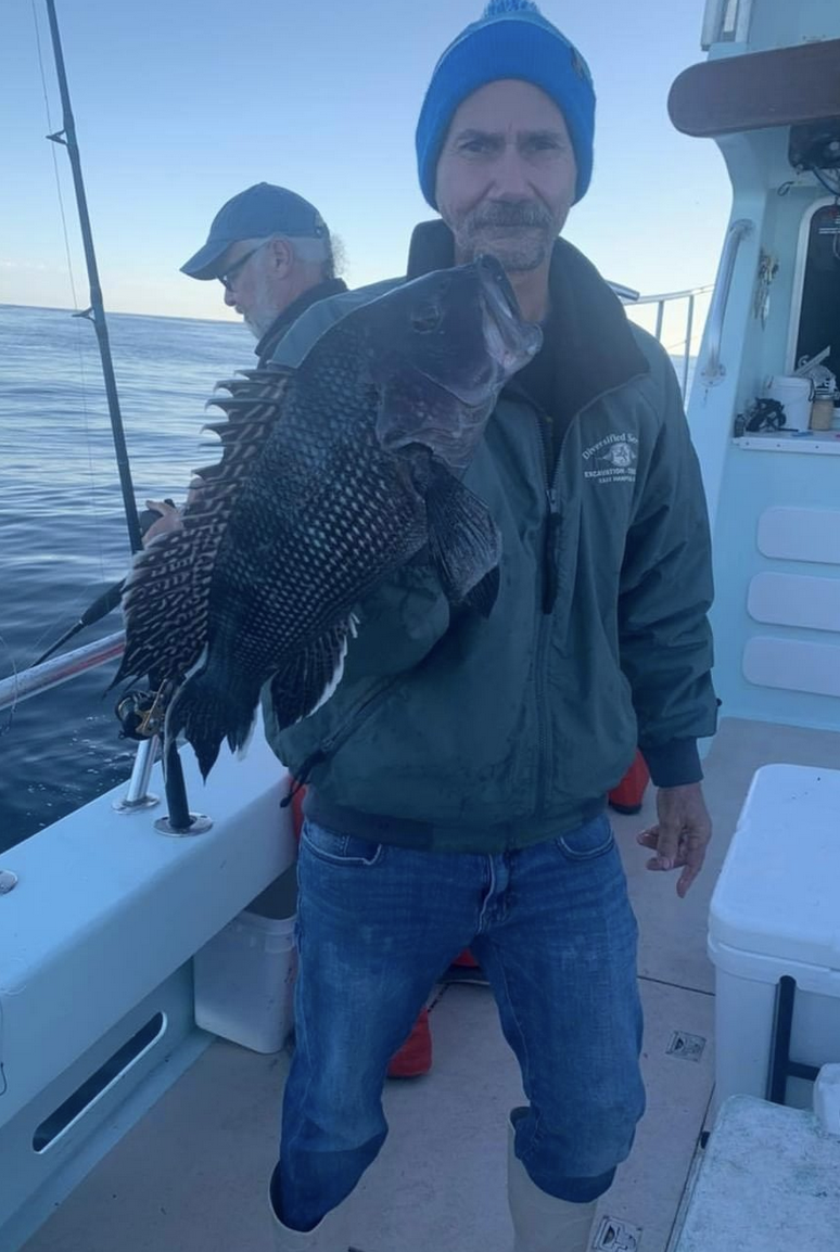 a man holding a fish on a boat