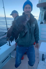 a man holding a fish on a boat