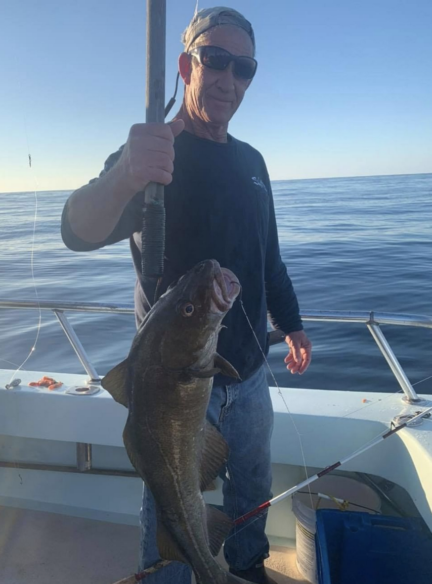 a man holding a fish on a boat