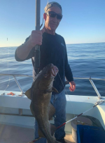 a man holding a fish on a boat
