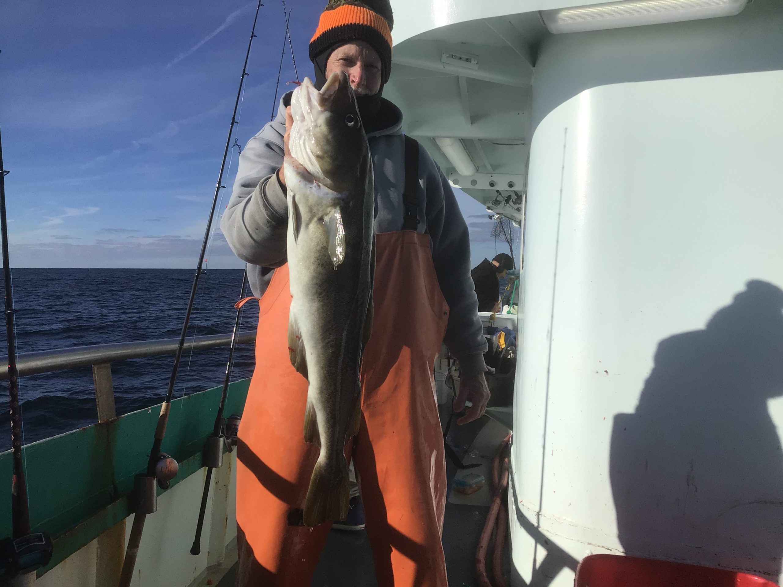 a person holding a fish on a boat