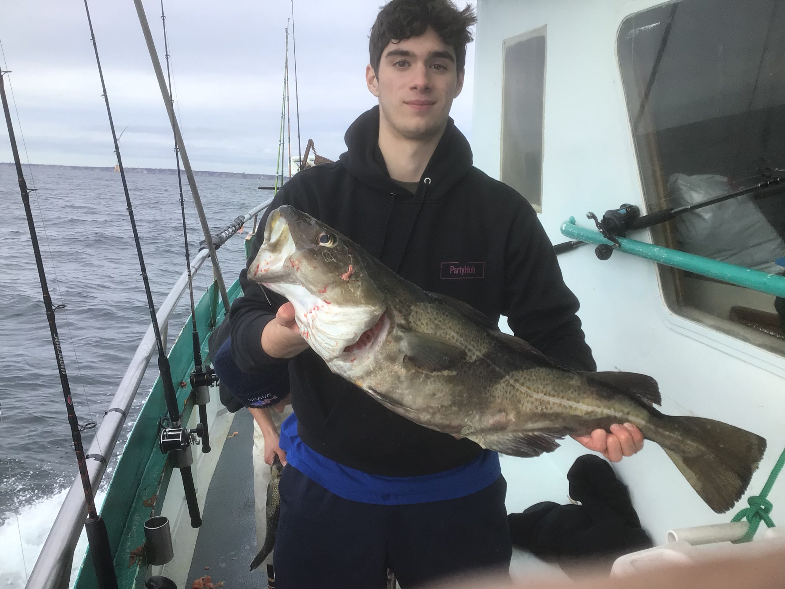 a man holding a fish on a boat in the water