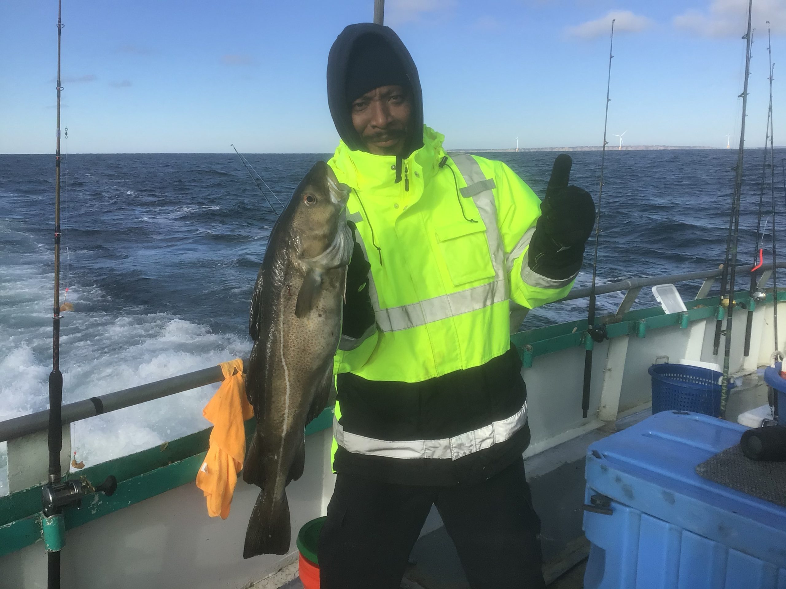 a person holding a fish on a boat in the water