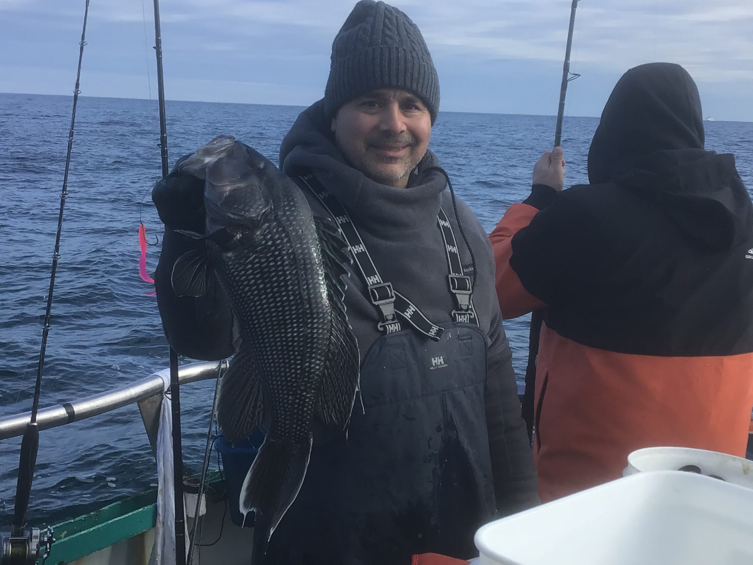 a person holding a fish on a boat in a body of water