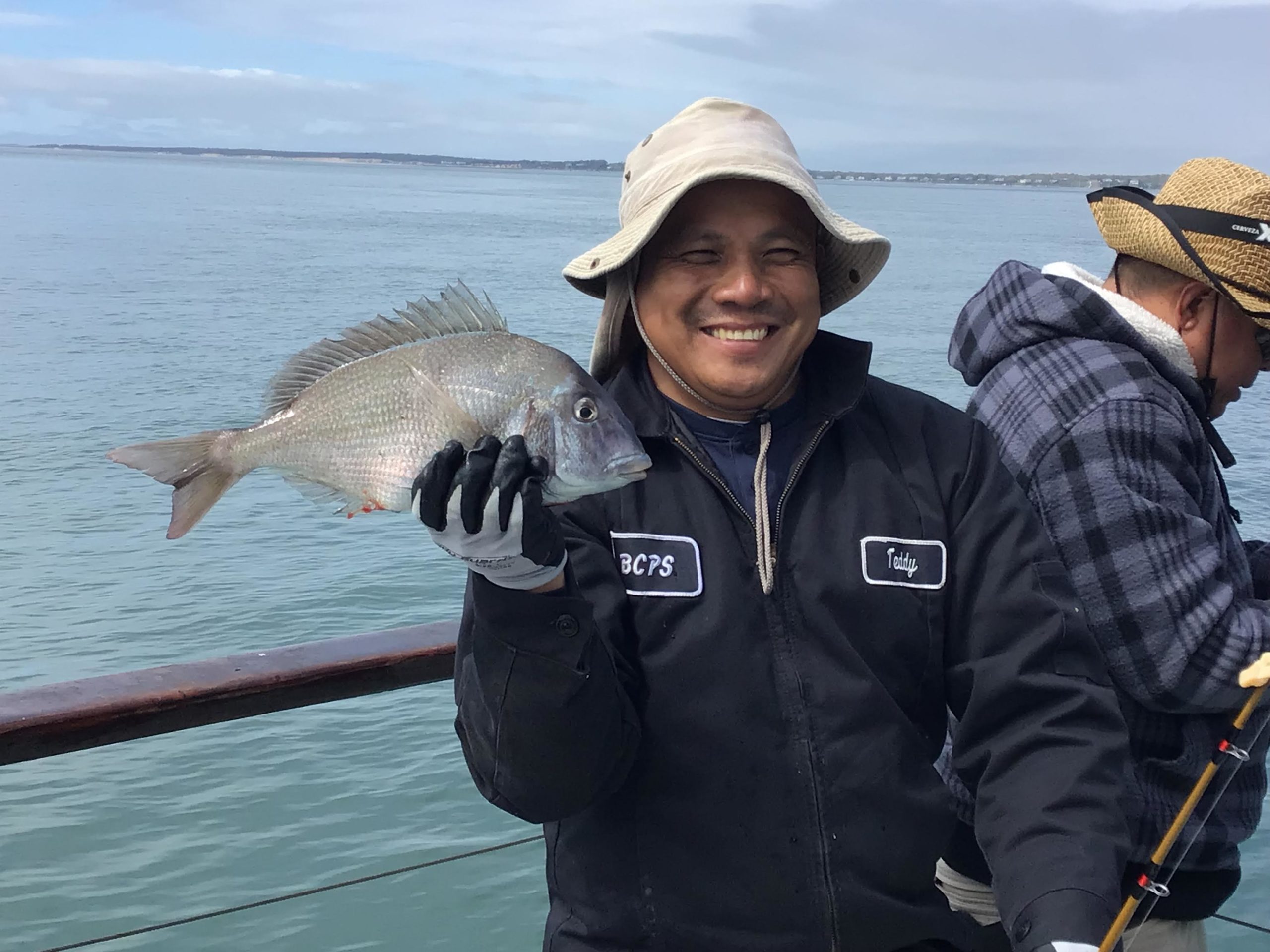 a person holding a fish on a boat in a body of water