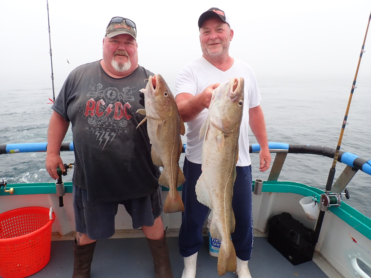 a man holding a fish on a boat posing for the camera