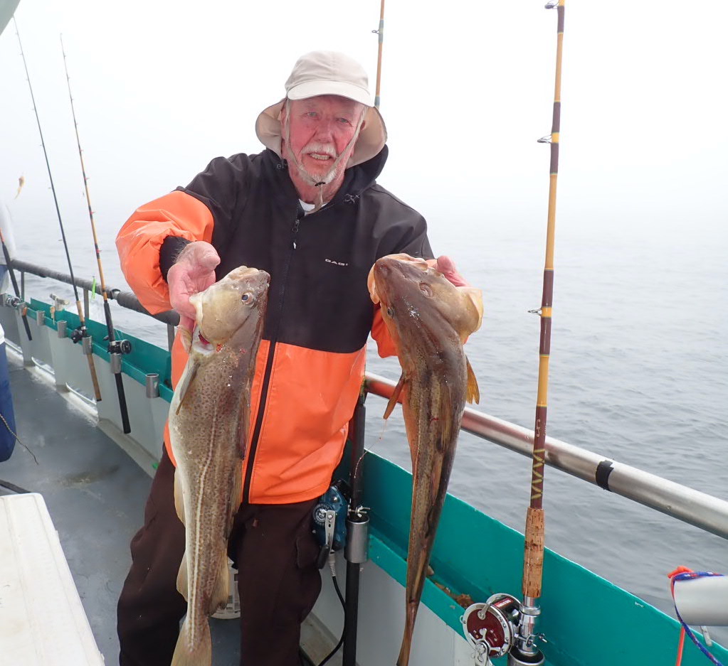 a man holding a fish on a boat