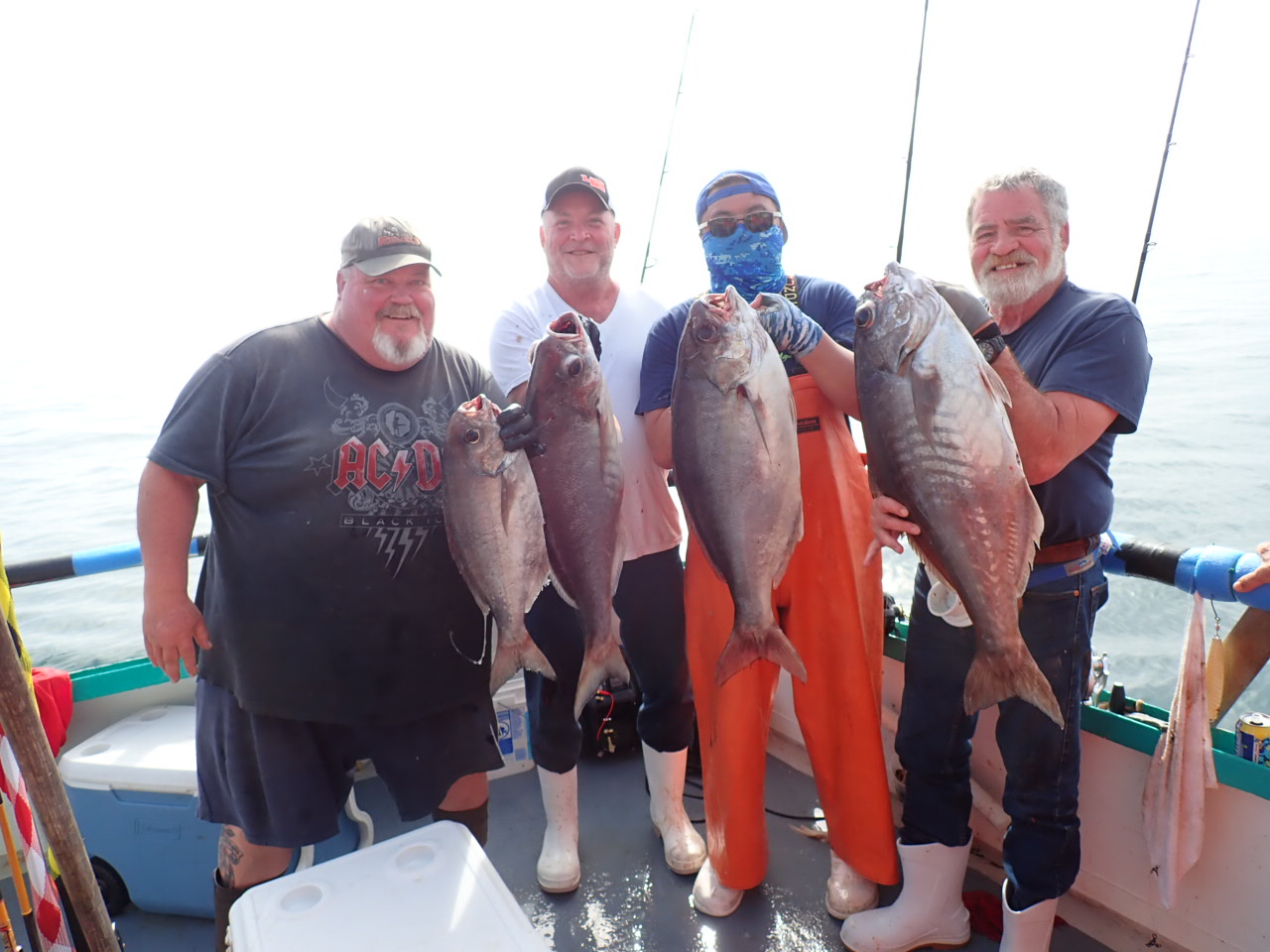 a group of people standing next to a man holding a fish