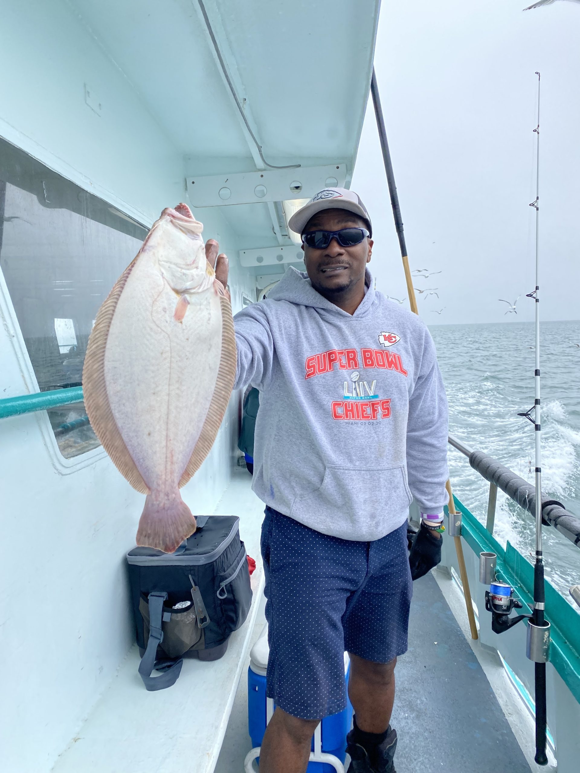 a man holding a fish on a boat