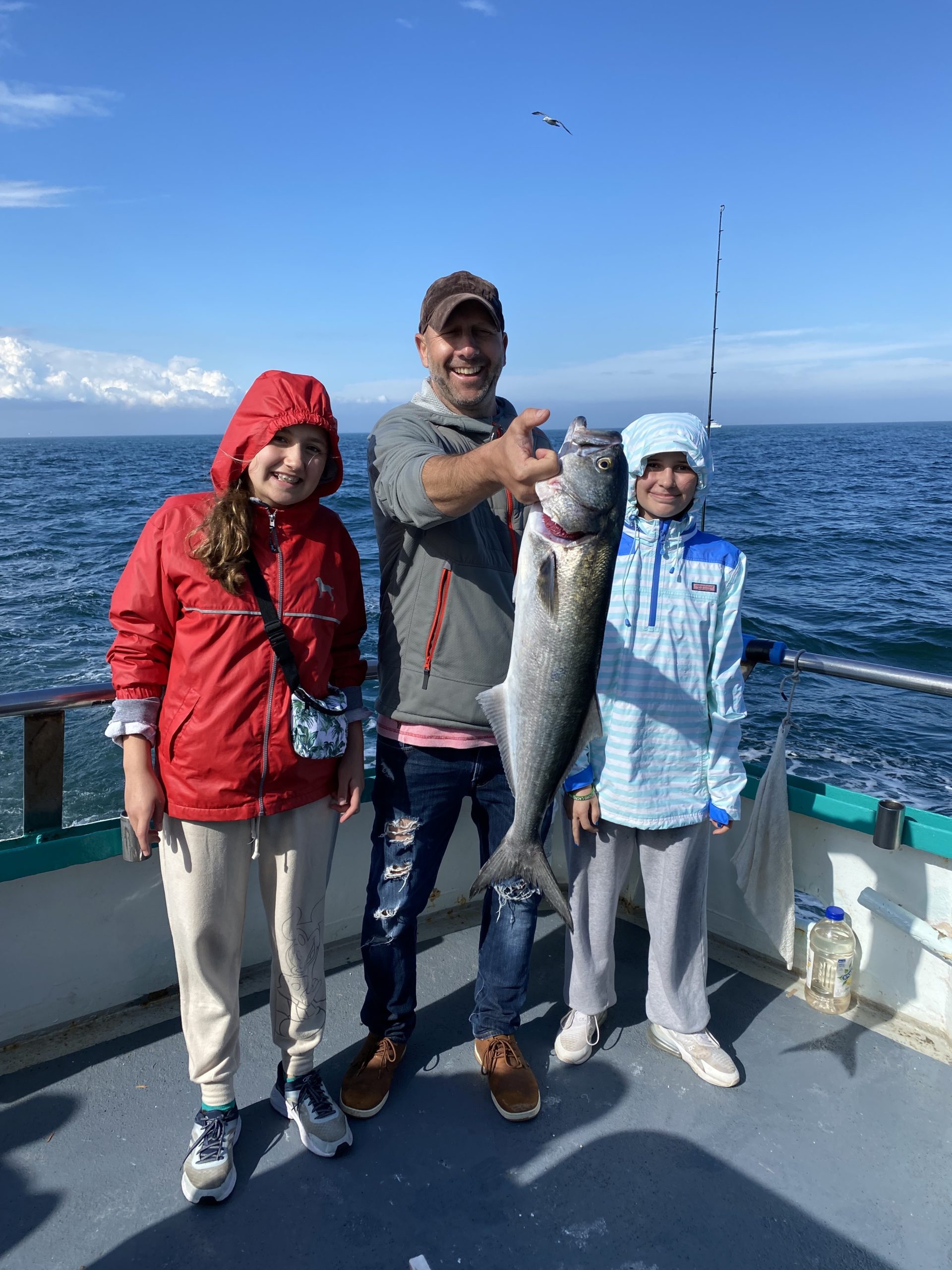 a group of people standing next to a fish in the water