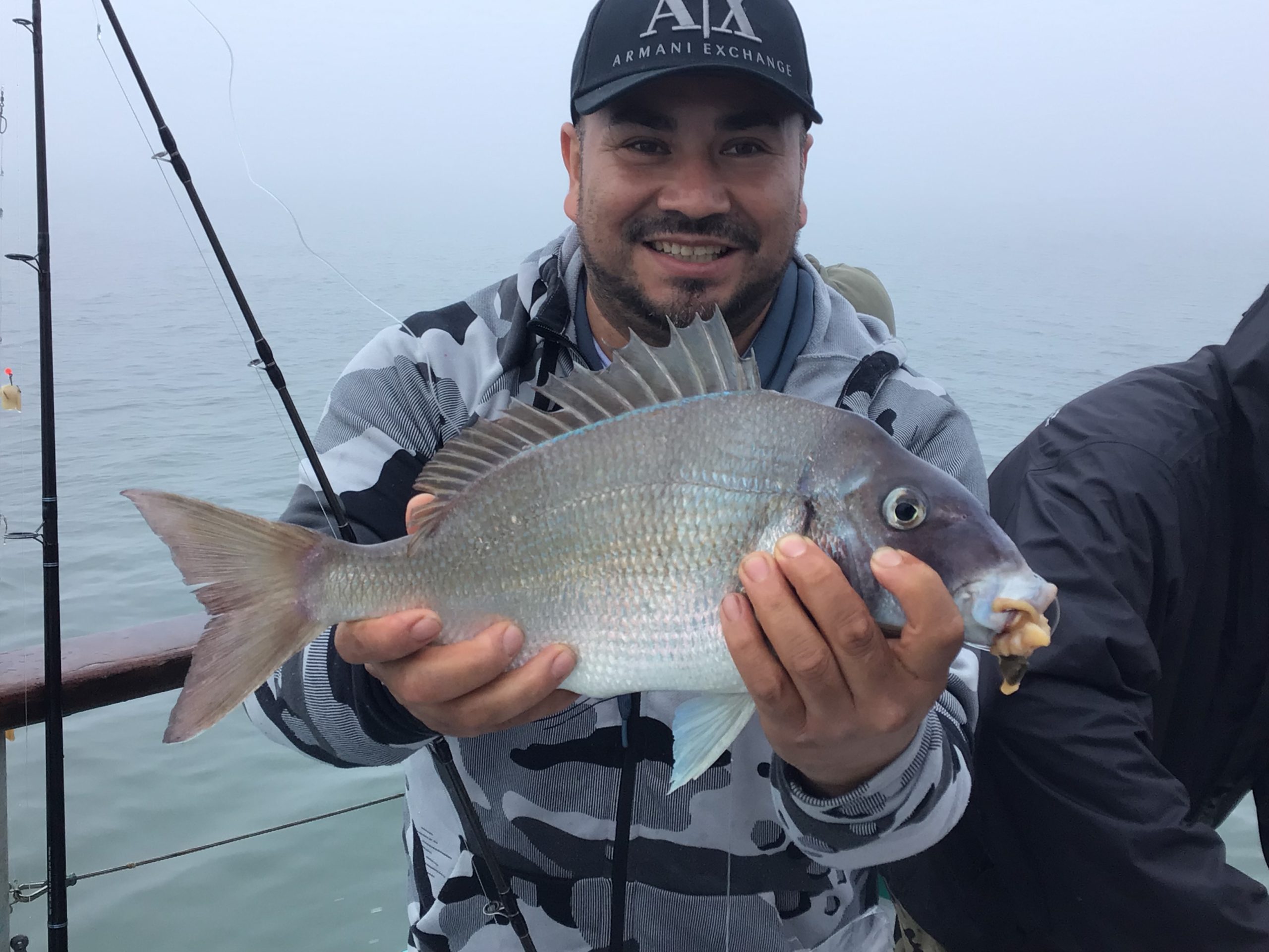 a person holding a fish on a boat in a body of water