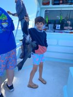 a young boy holding a blue umbrella