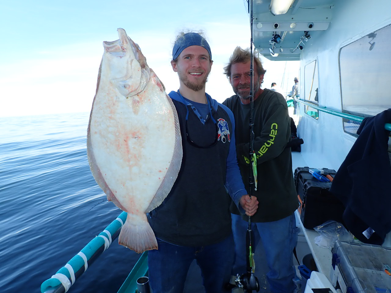 a person holding a fish posing for the camera