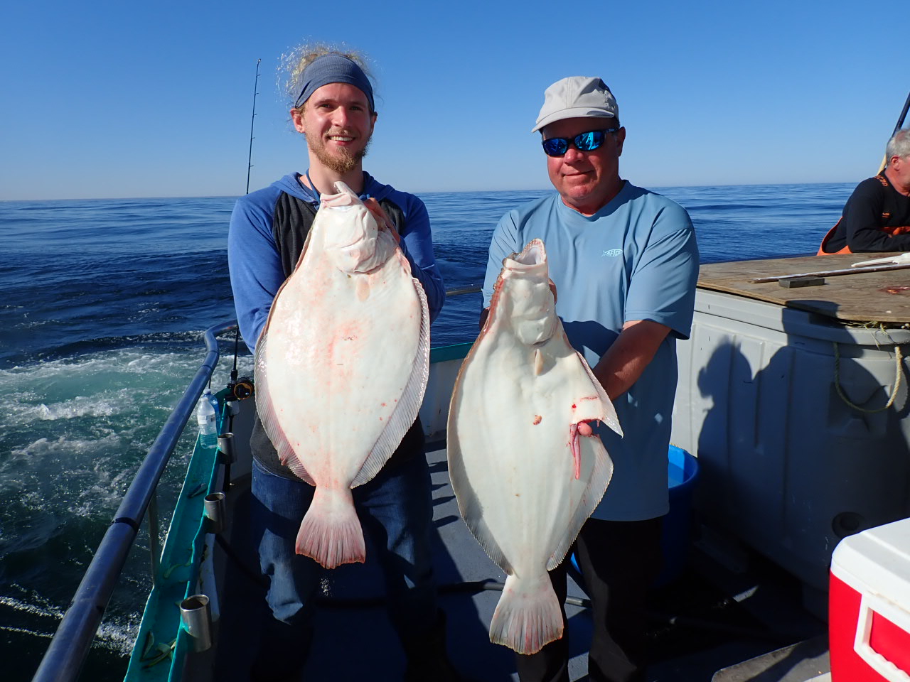 a man holding a fish on a boat in the water
