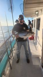 a man holding a fish on a boat