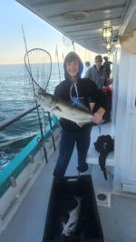 a man holding a fish on a boat