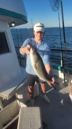 a man holding a fish on a boat in the water