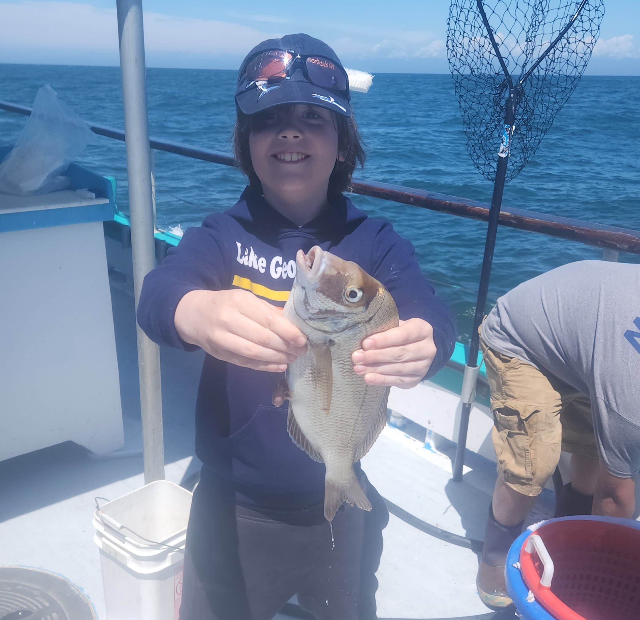 a person holding a fish on a boat posing for the camera
