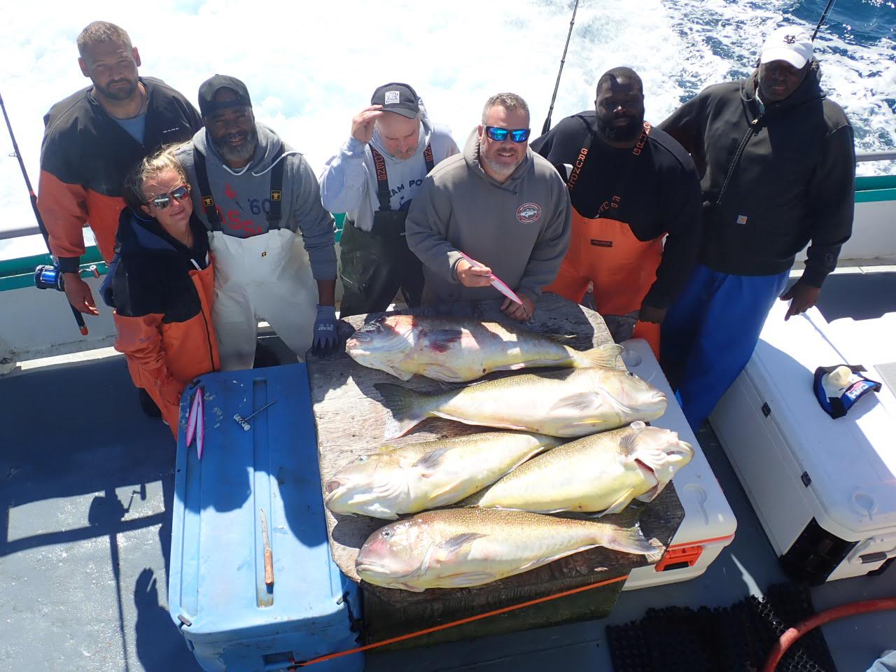 a group of people standing in front of a fish