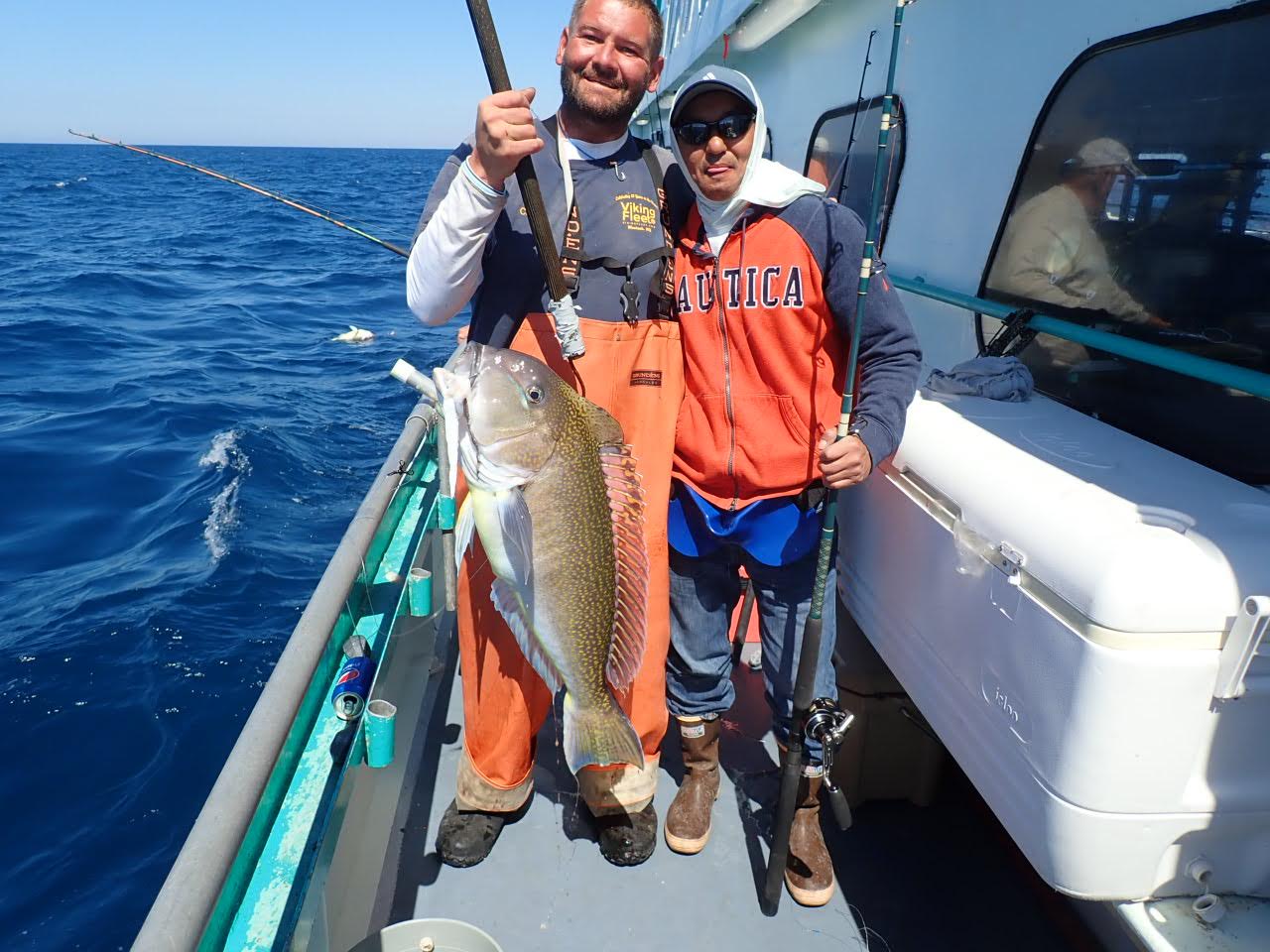 a man holding a fish on a boat