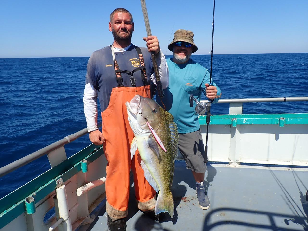 a man holding a fish on a boat