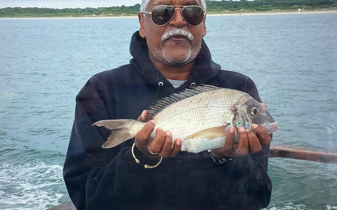 a man holding a fish swimming under water