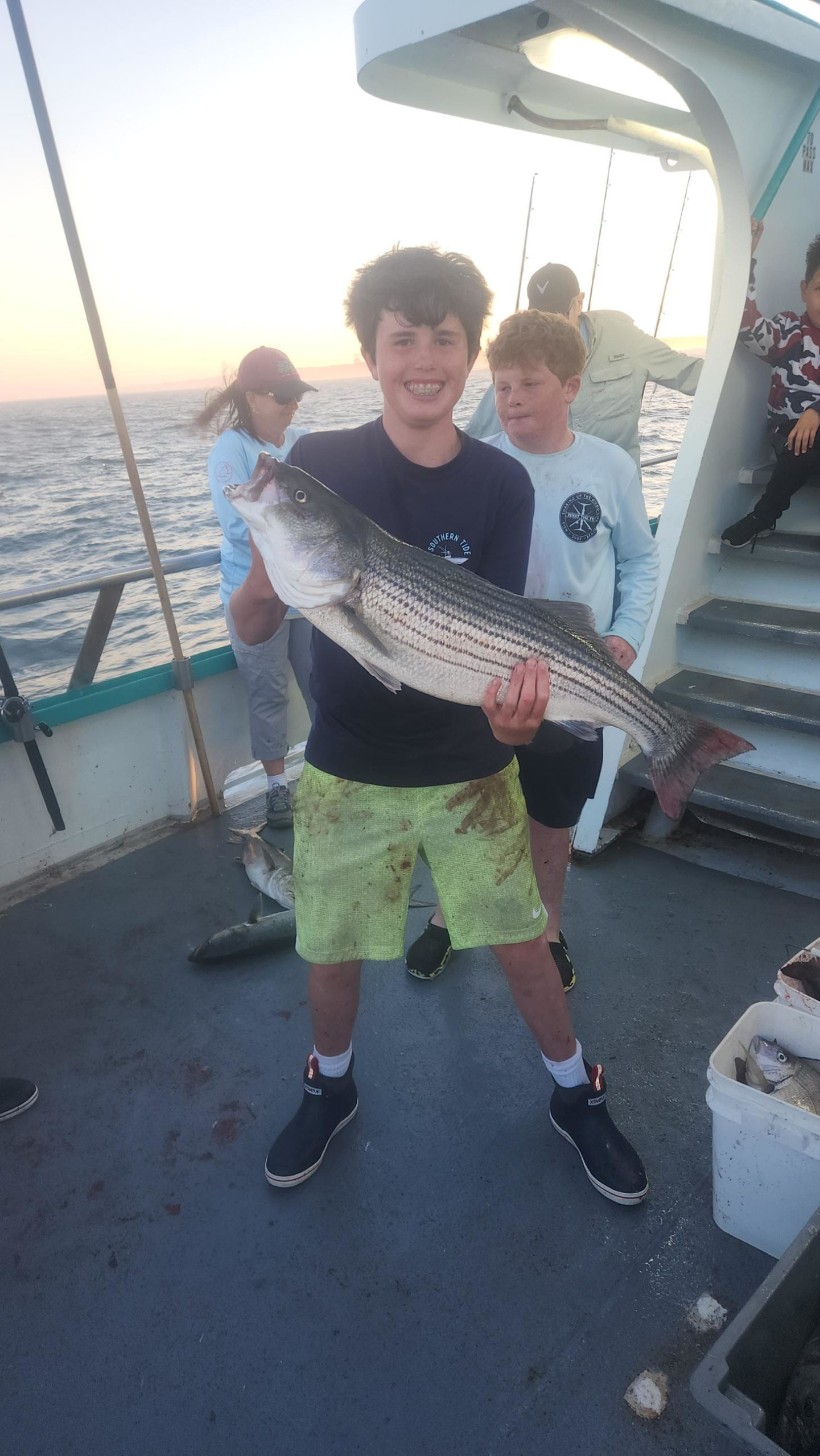 a young boy holding a fish