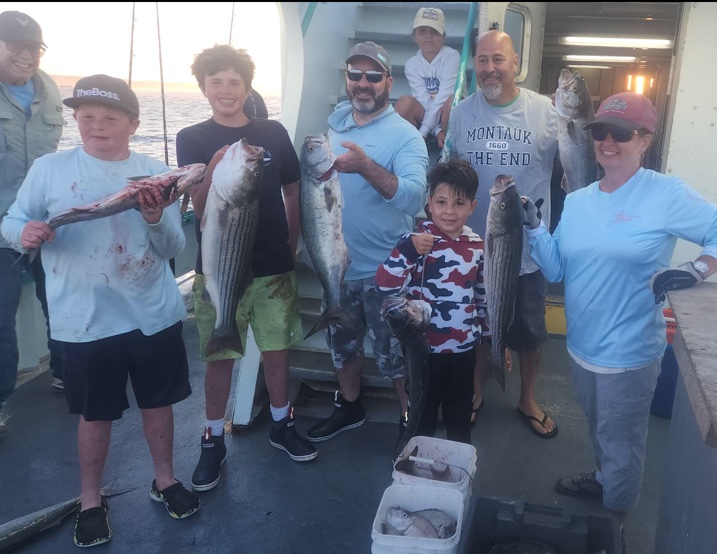 a group of people standing in front of a fish