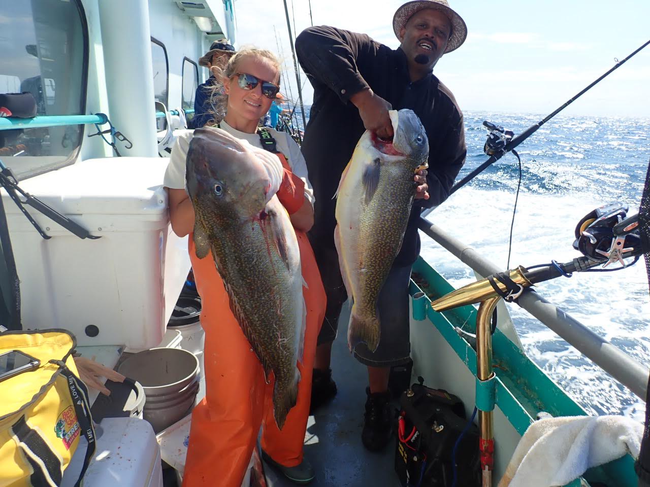 a man holding a fish on a boat