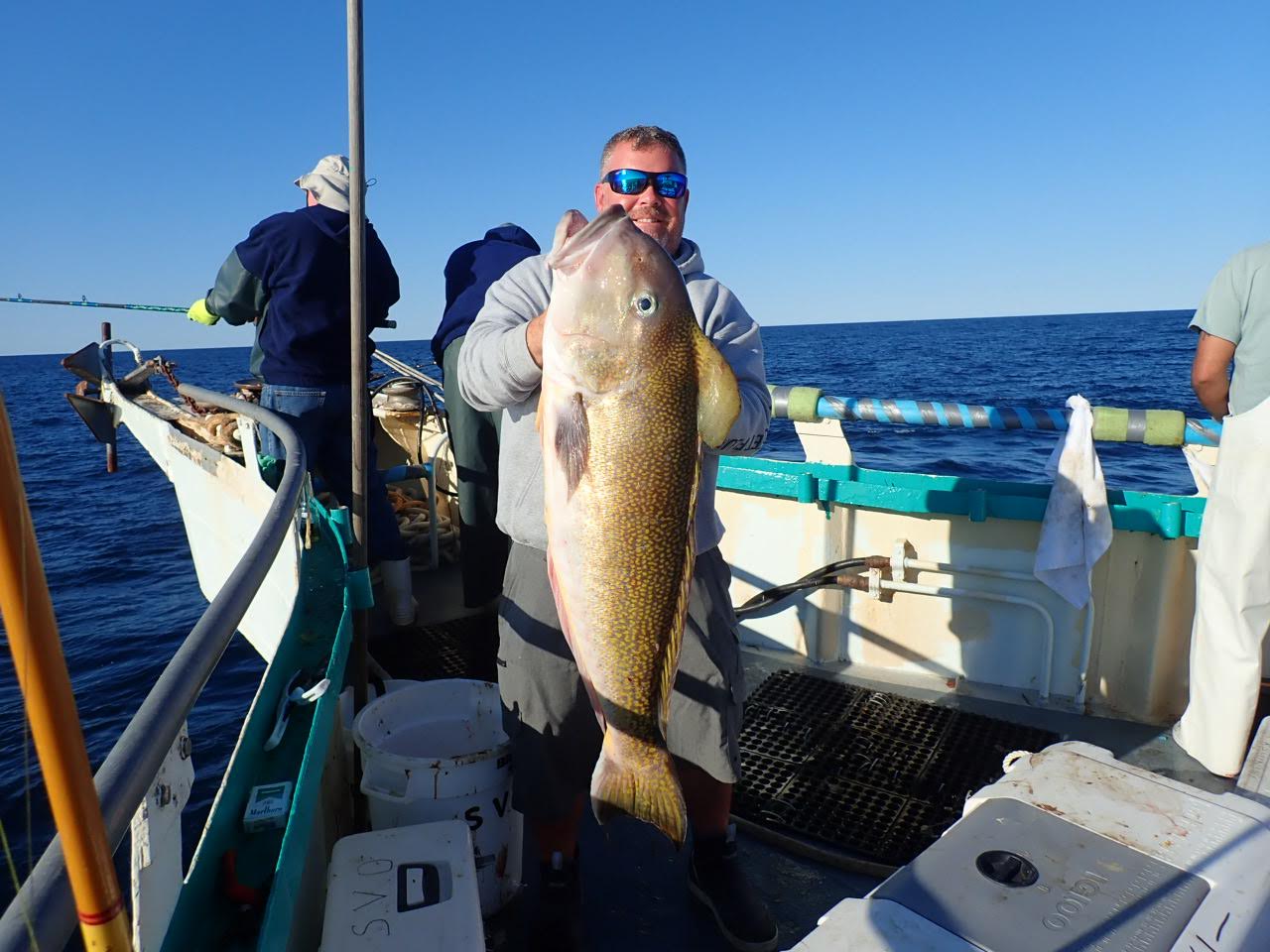 a person holding a fish on a boat