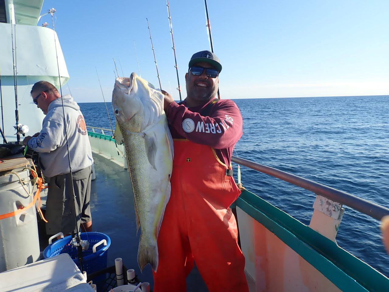 a man holding a fish on a boat