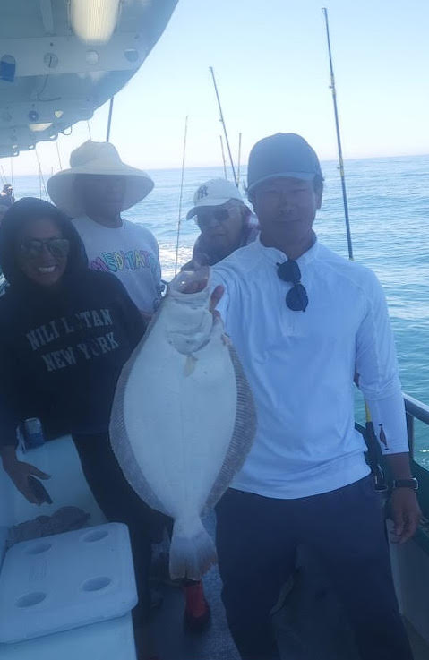 a man holding a fish on a boat
